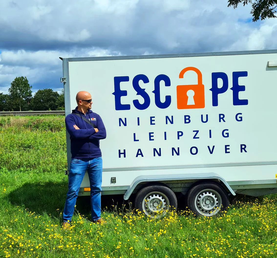 Artur Hammerschmidt vor dem Escape-Universe-Anhänger mit den Standorten Nienburg, Leipzig und Hannover
